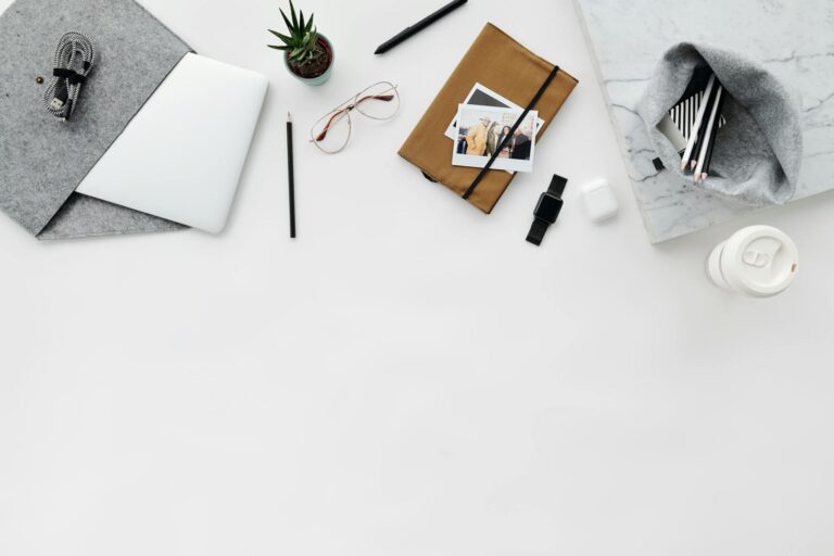 Flat lay of modern workspace with laptop, journal, gadgets, and ample copy space.