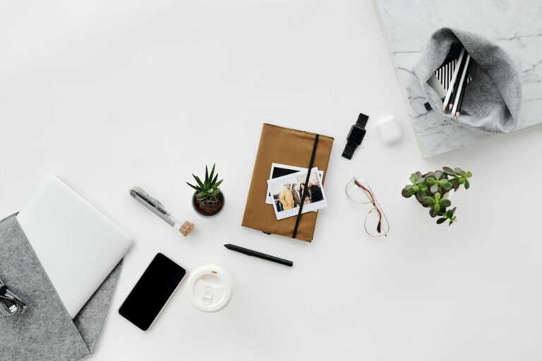 Top view of a stylish and minimalist workspace featuring office supplies and gadgets in an aesthetic layout.